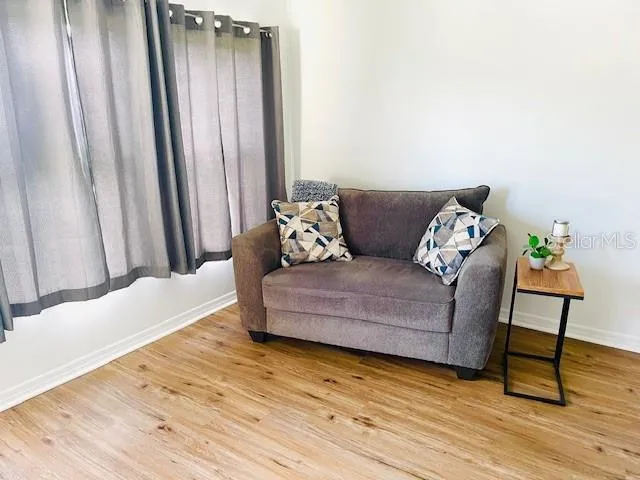 a living room with furniture and wooden floor
