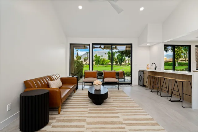 a living room with furniture fireplace and a large window