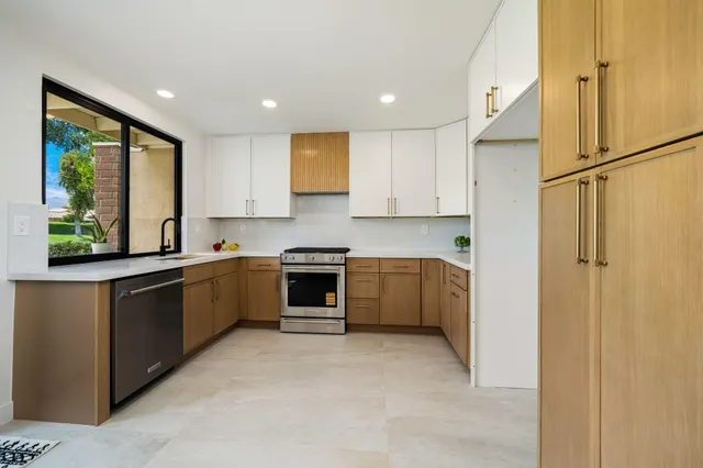 a kitchen with stainless steel appliances granite countertop a refrigerator sink and stove