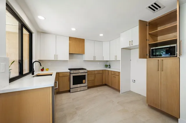 a kitchen with stainless steel appliances granite countertop a stove a sink and a refrigerator