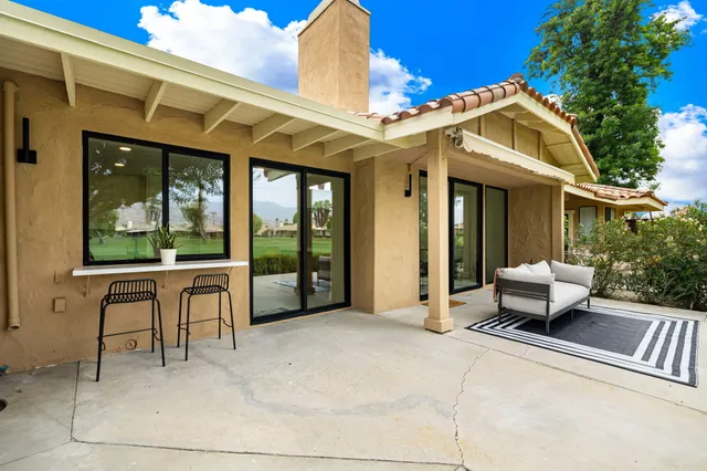 a patio with sofas table and chairs