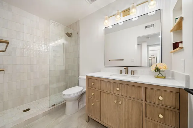 a bathroom with a granite countertop sink a toilet and a mirror
