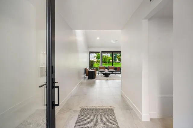 a view of a hallway with a livingroom and a livingroom with furniture