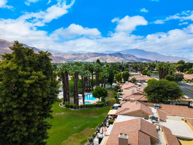 an aerial view of residential houses with outdoor space and trees