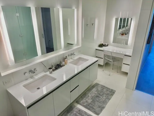 a bathroom with a double vanity sink a mirror and a toilet