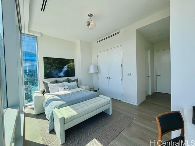 1118 Ala Moana Boulevard, Unit 3403 Honolulu, HI 96814 - Photo 22 of 24 a bedroom with a bed and glass wall