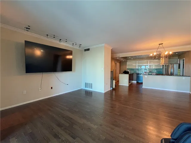 a view of a dining room with furniture a chandelier and wooden floor