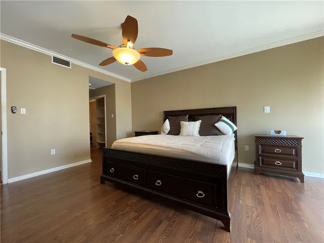 a spacious bedroom with a bed and a ceiling fan