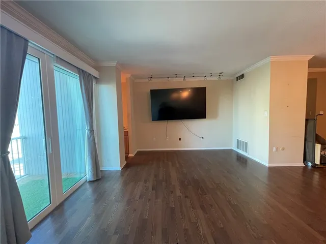a view of a livingroom with wooden floor and flat screen tv