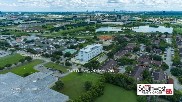 an aerial view of residential houses with outdoor space and trees