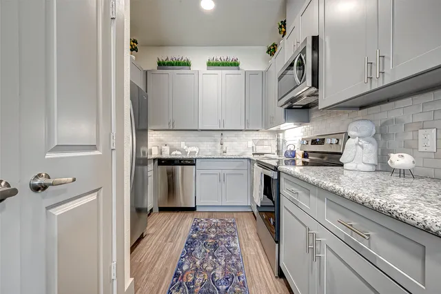a kitchen with granite countertop cabinets stainless steel appliances and a counter space