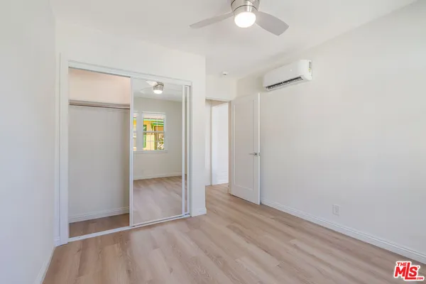 an empty room with wooden floor and mirror