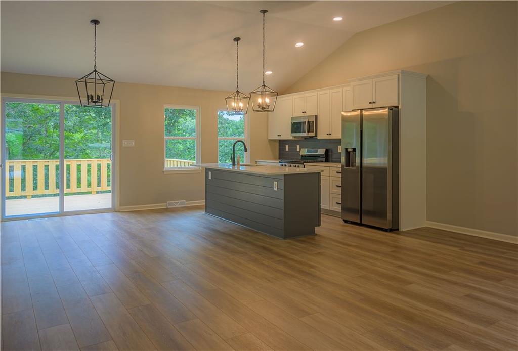 2392 Ridge Rd Extension Ambridge, PA 15003 - Photo 13 of 37 a kitchen with stainless steel appliances granite countertop a refrigerator a sink a stove and a wooden floors