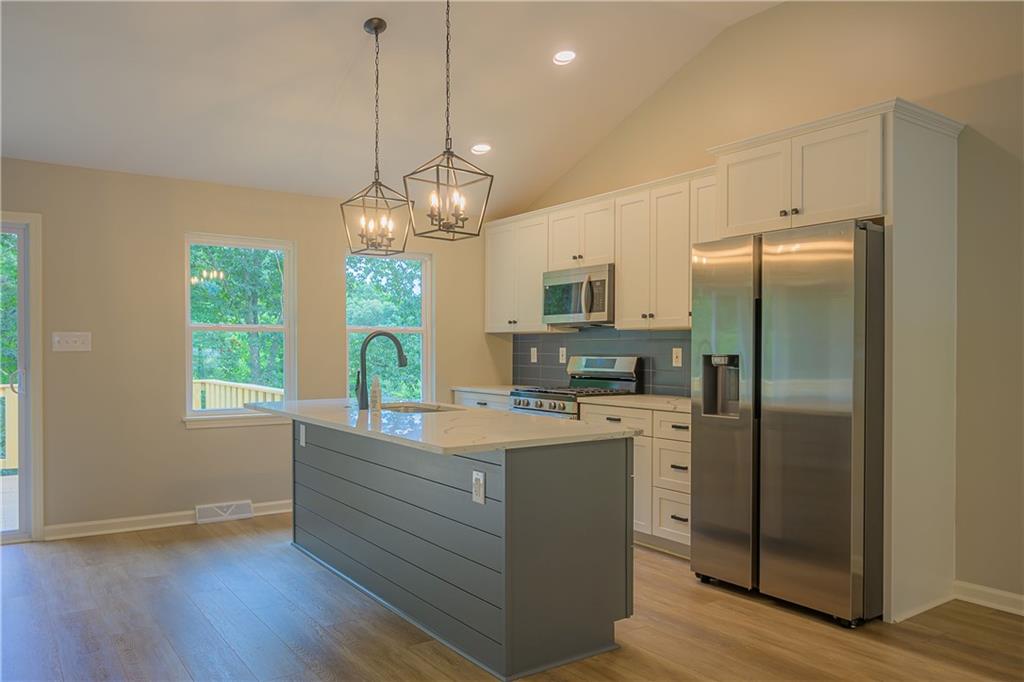 2392 Ridge Rd Extension Ambridge, PA 15003 - Photo 17 of 37 a kitchen with stainless steel appliances granite countertop a refrigerator a oven a stove and a wooden floors
