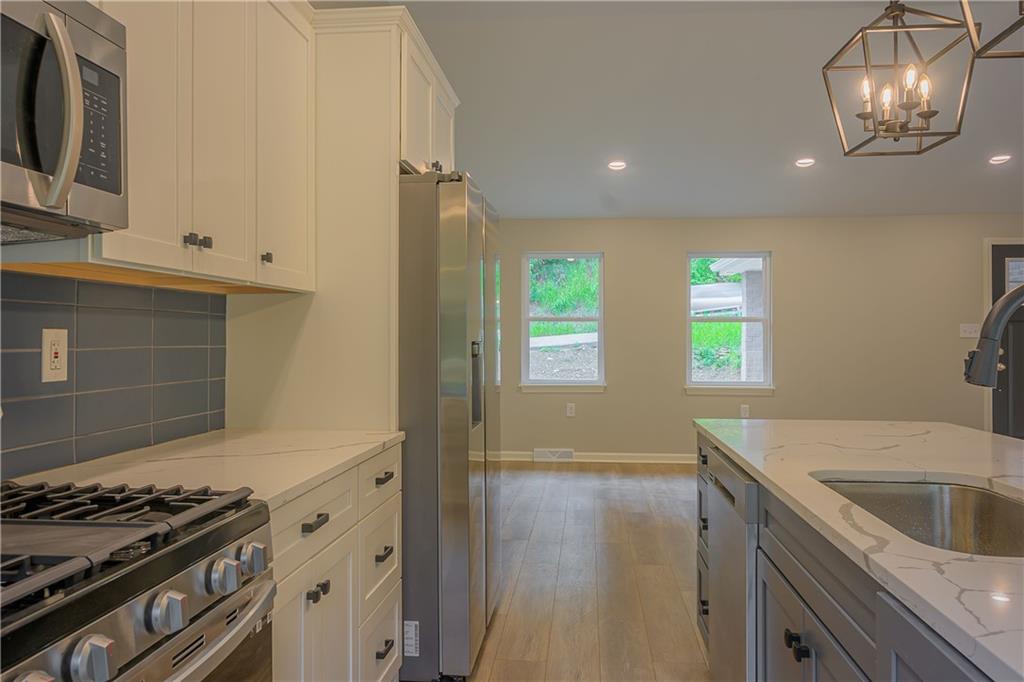 2392 Ridge Rd Extension Ambridge, PA 15003 - Photo 23 of 37 a kitchen that has a sink wooden floor and stainless steel appliances