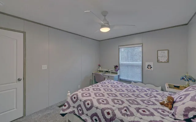 a bedroom with a bed and a lamp on dresser