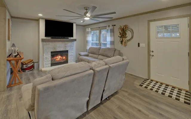 a living room with furniture a flat screen tv and a fireplace