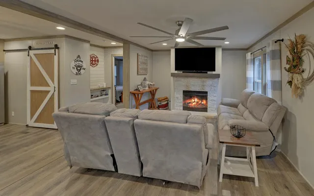 a living room with furniture a fireplace and a flat screen tv