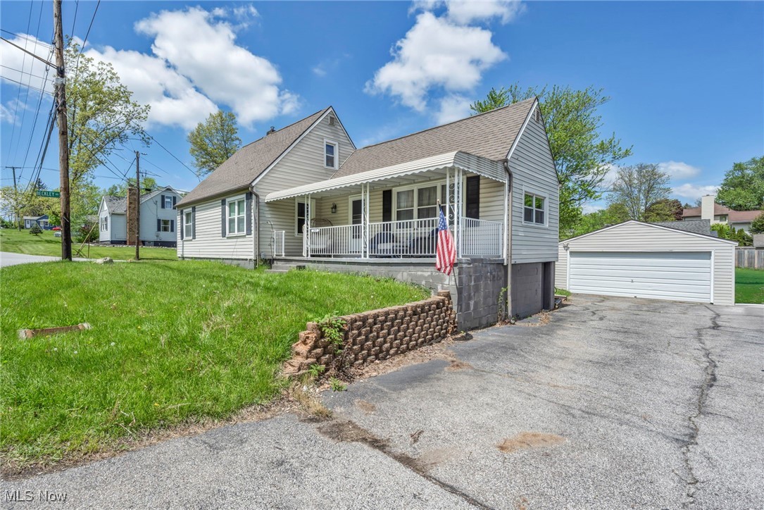 2669 Graham Road Stow, OH 44224 - Photo 1 of 29 View of front of home featuring covered porch, a detached garage, an outdoor structure, roof with shingles, and a front yard