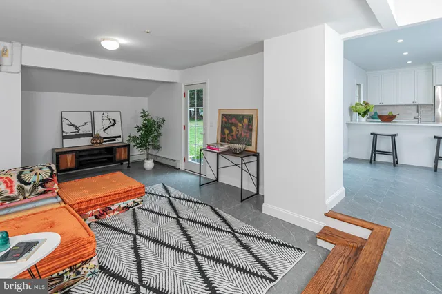 a living room with furniture a rug and kitchen view