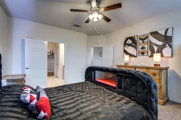 a bedroom with a large bed and a chandelier