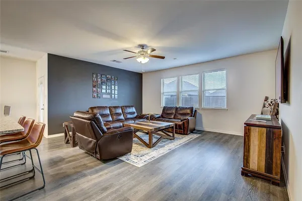 a living room with furniture a window and wooden floor