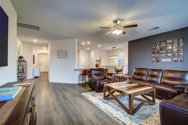 a living room with furniture a ceiling fan and a rug