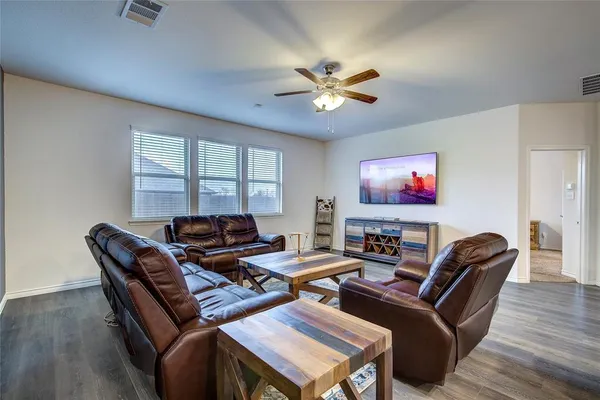 a living room with furniture a ceiling fan and a window