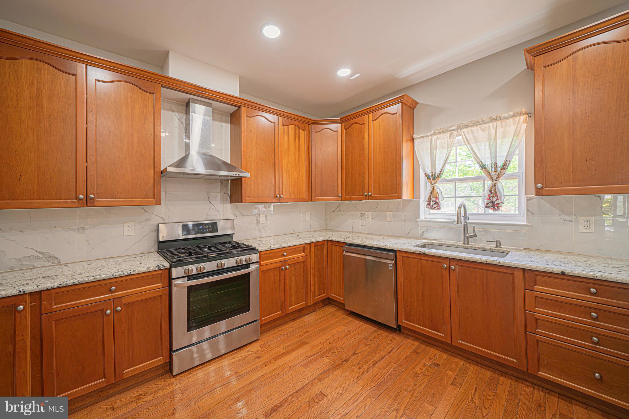 54 Arbor Circle Colmar, PA 18915 - Photo 15 of 74 a kitchen with stainless steel appliances granite countertop wooden floor sink stove and a granite counter top