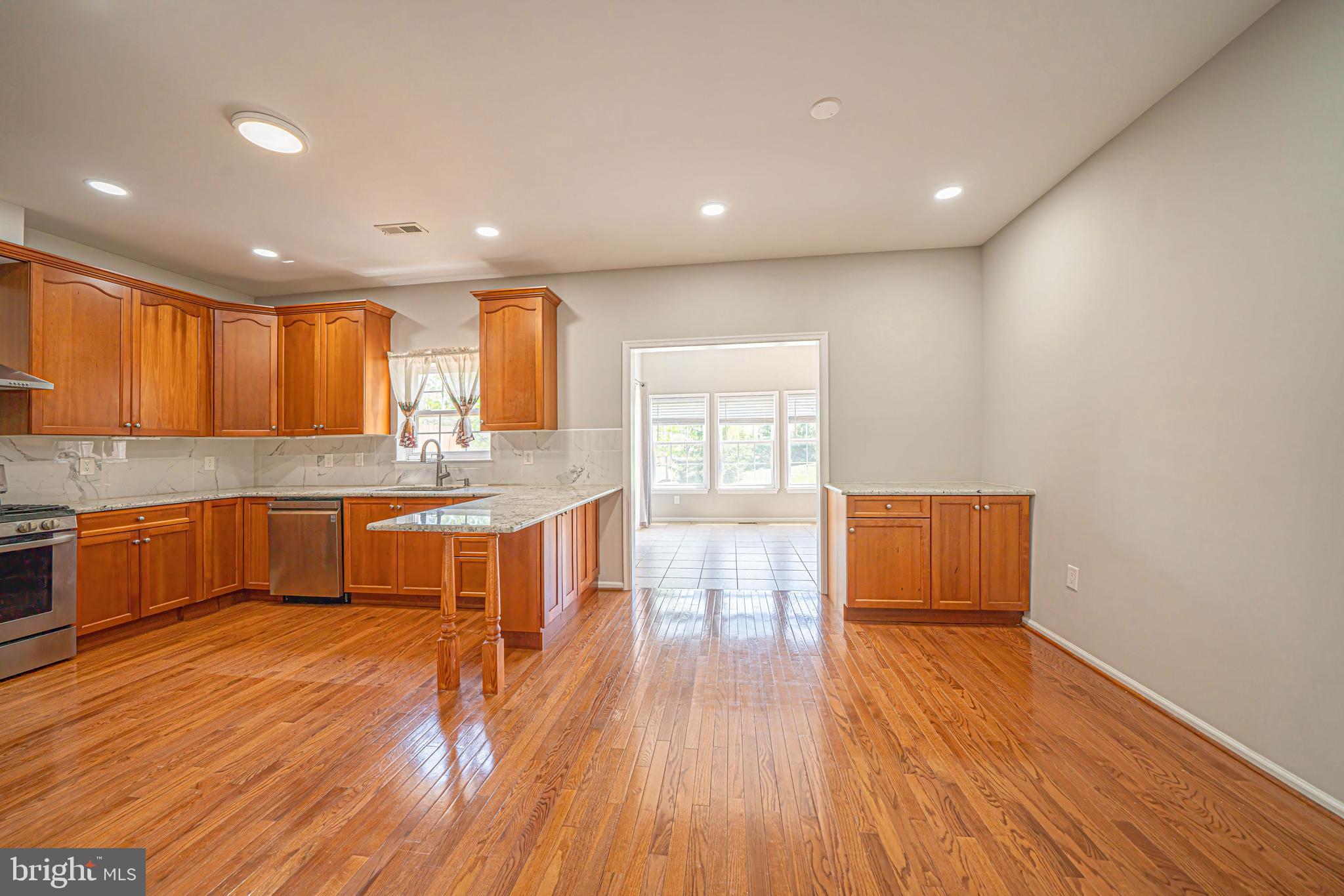 54 Arbor Circle Colmar, PA 18915 - Photo 26 of 74 a large kitchen with stainless steel appliances granite countertop a large counter top a sink and dishwasher a oven with wooden floors