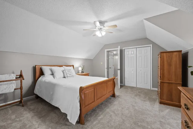 a bedroom with a bed and a refrigerator