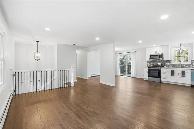 a view of a kitchen with a sink and dishwasher a stove with wooden floor