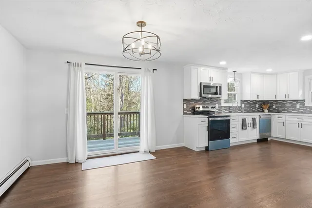 a kitchen with stainless steel appliances granite countertop a stove top oven a sink and a chandelier