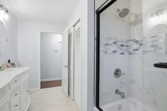 a bathroom with a bathtub sink and mirror