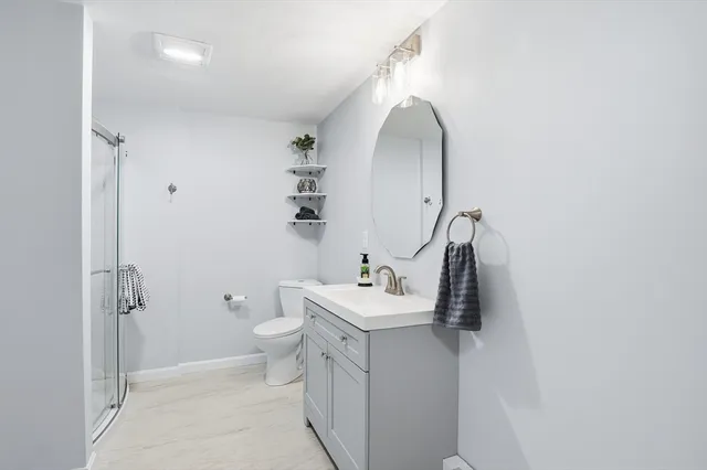 a bathroom with a sink and mirror with toilet