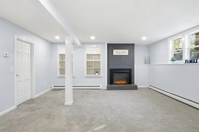 a view of an empty room with window and fire place