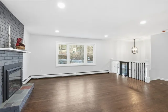 an empty room with wooden floor and fireplace