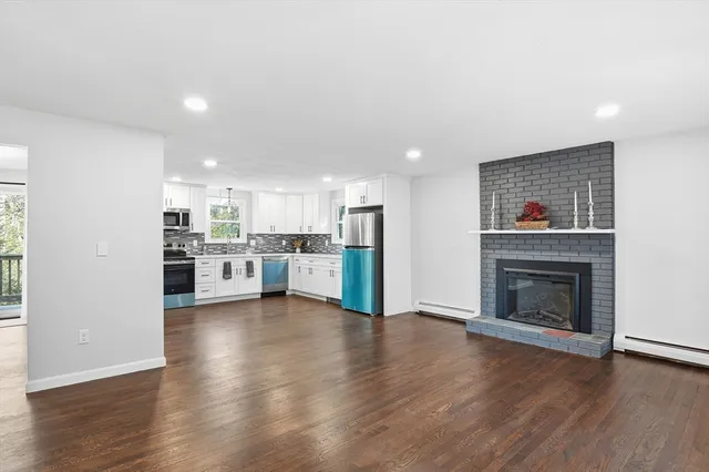 a view of kitchen with wooden floor and a fireplace