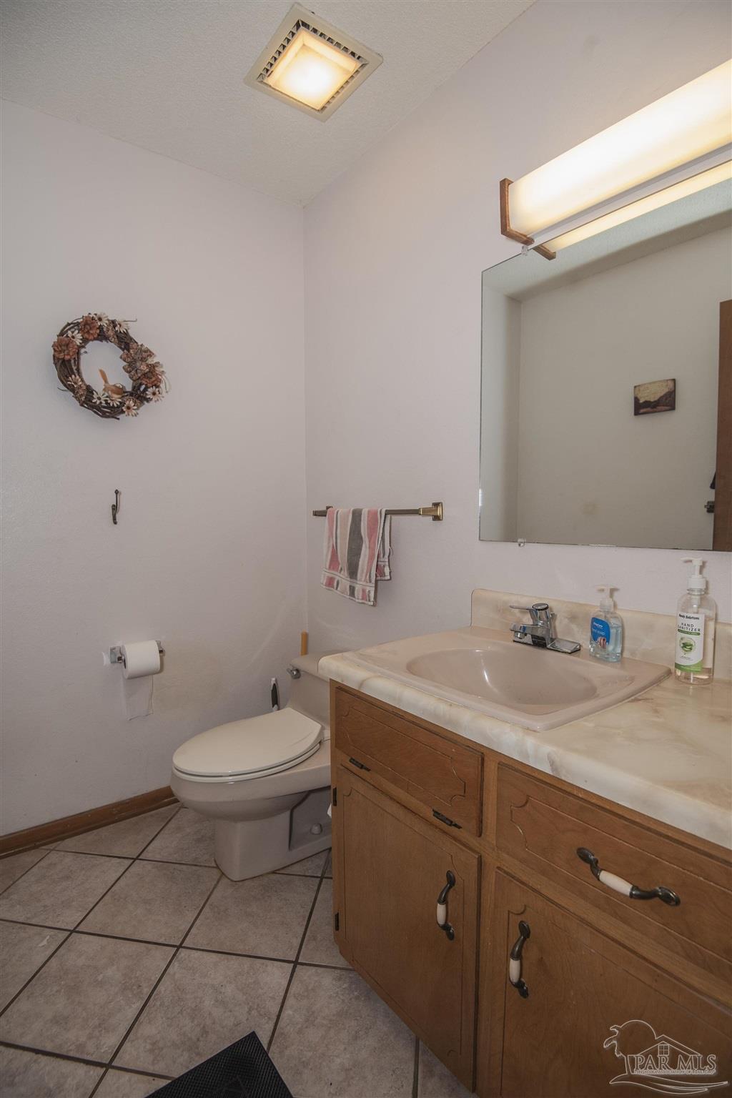 1210 Goldenrod Road Cantonment, FL 32533 - Photo 15 of 50 a bathroom with a toilet a sink and mirror