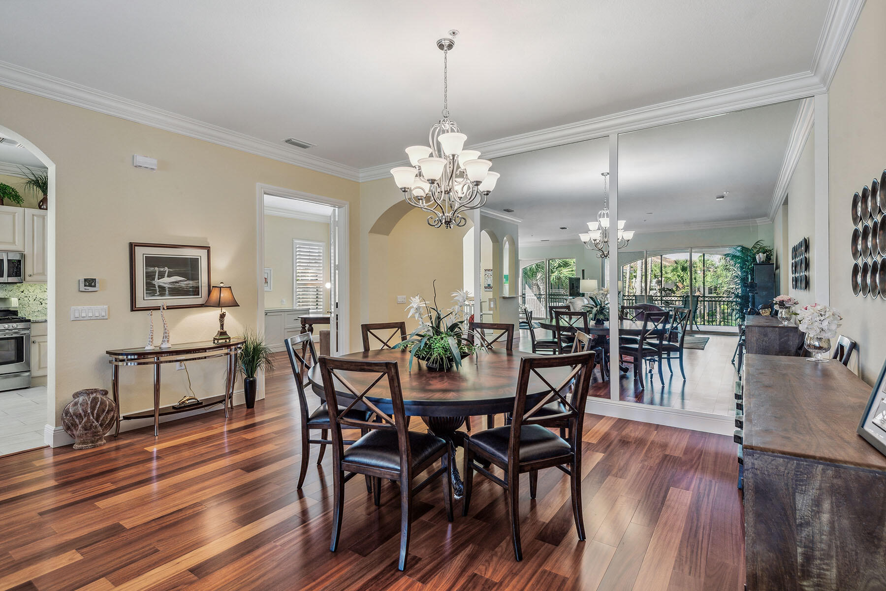 3189 Aviamar Circle, Unit 202 Naples, FL 34114 - Photo 7 of 50 a dining room with furniture a chandelier and wooden floor
