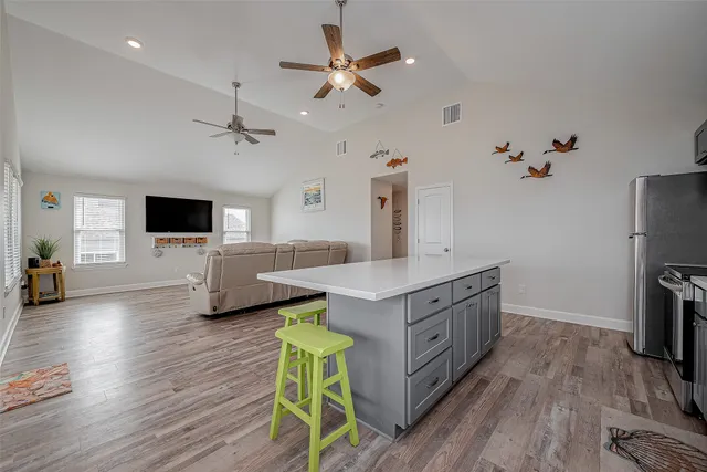 a kitchen with stainless steel appliances a kitchen island a stove and a wooden floors