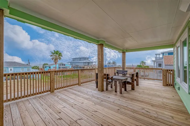 a view of a roof deck with table and chairs floor to ceiling window with wooden floor