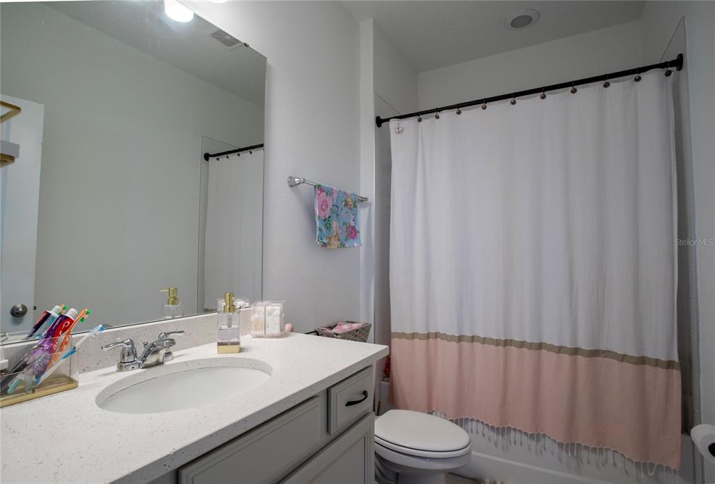 4724 Cragmere Loop Clermont, FL 34711 - Photo 22 of 37 a bathroom with a sink a toilet and shower curtain
