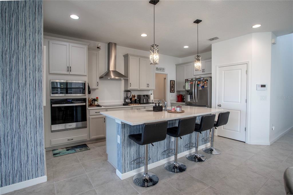 4724 Cragmere Loop Clermont, FL 34711 - Photo 7 of 37 a kitchen with kitchen island granite countertop a sink and a refrigerator