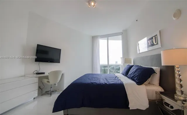 a bedroom with a bed and a flat screen tv