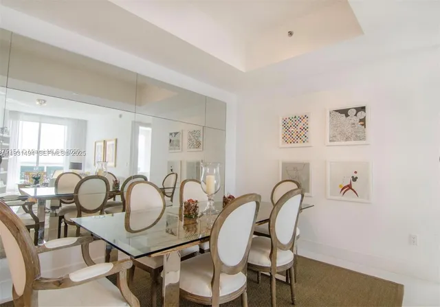 a dining room with wooden floor and large windows