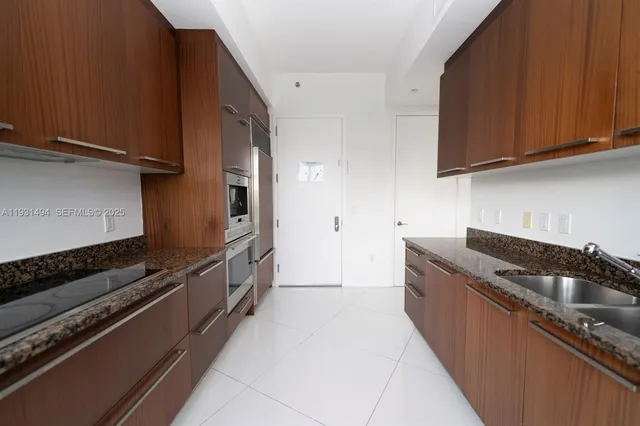 a kitchen with granite countertop a stove and cabinets