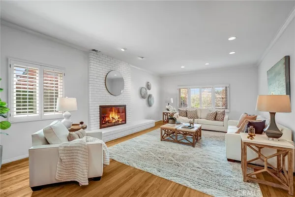 a dining room with wooden floor a chandelier fan a wooden table and chairs