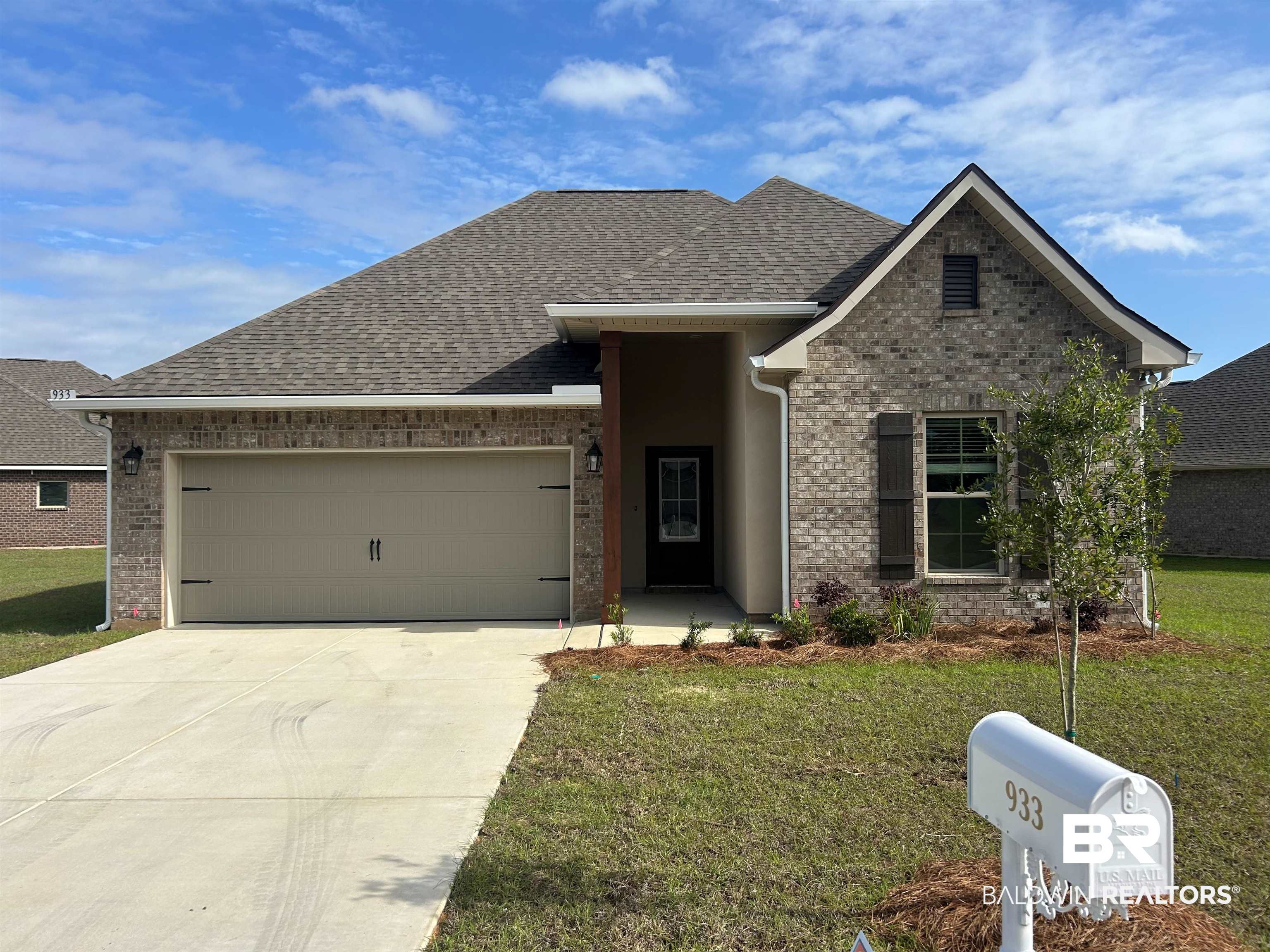 933 Ashville Circle Foley, AL 36535 - Photo 1 of 3 View of front of home featuring an attached garage, brick siding, concrete driveway, roof with shingles, and a front lawn