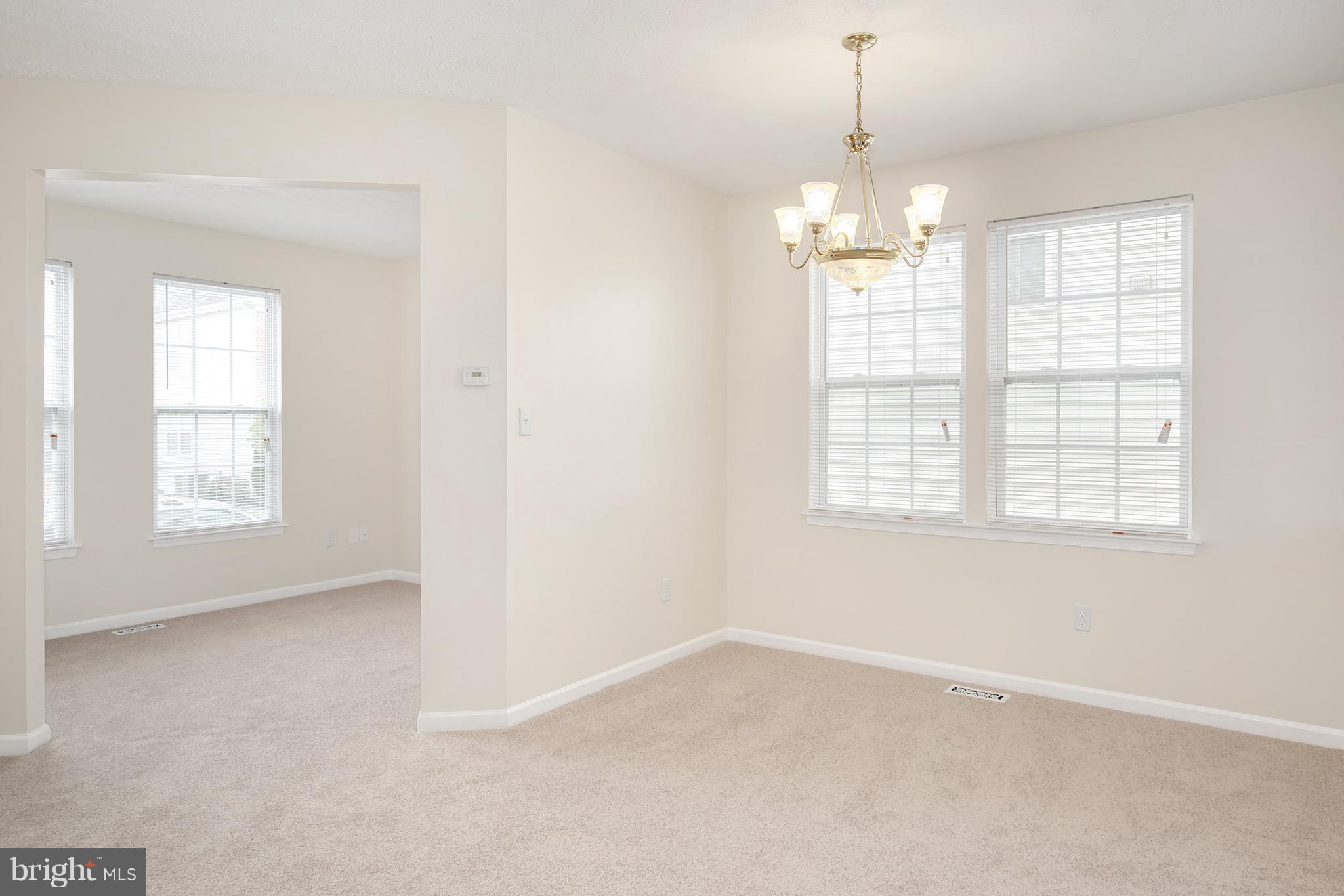 718 Luke Road Baltimore, MD 21220 - Photo 14 of 30 an empty room with windows and chandelier